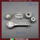 Fine silver musical set by Utsav Arts featuring intricate designs and instruments, displayed on a wooden surface.