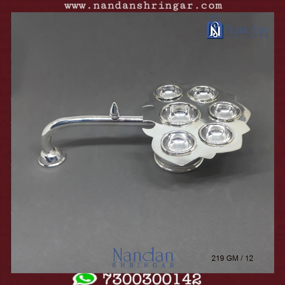 Fine silver Aarti by Utsav Arts, featuring intricate design and craftsmanship, displayed in elegant lighting.